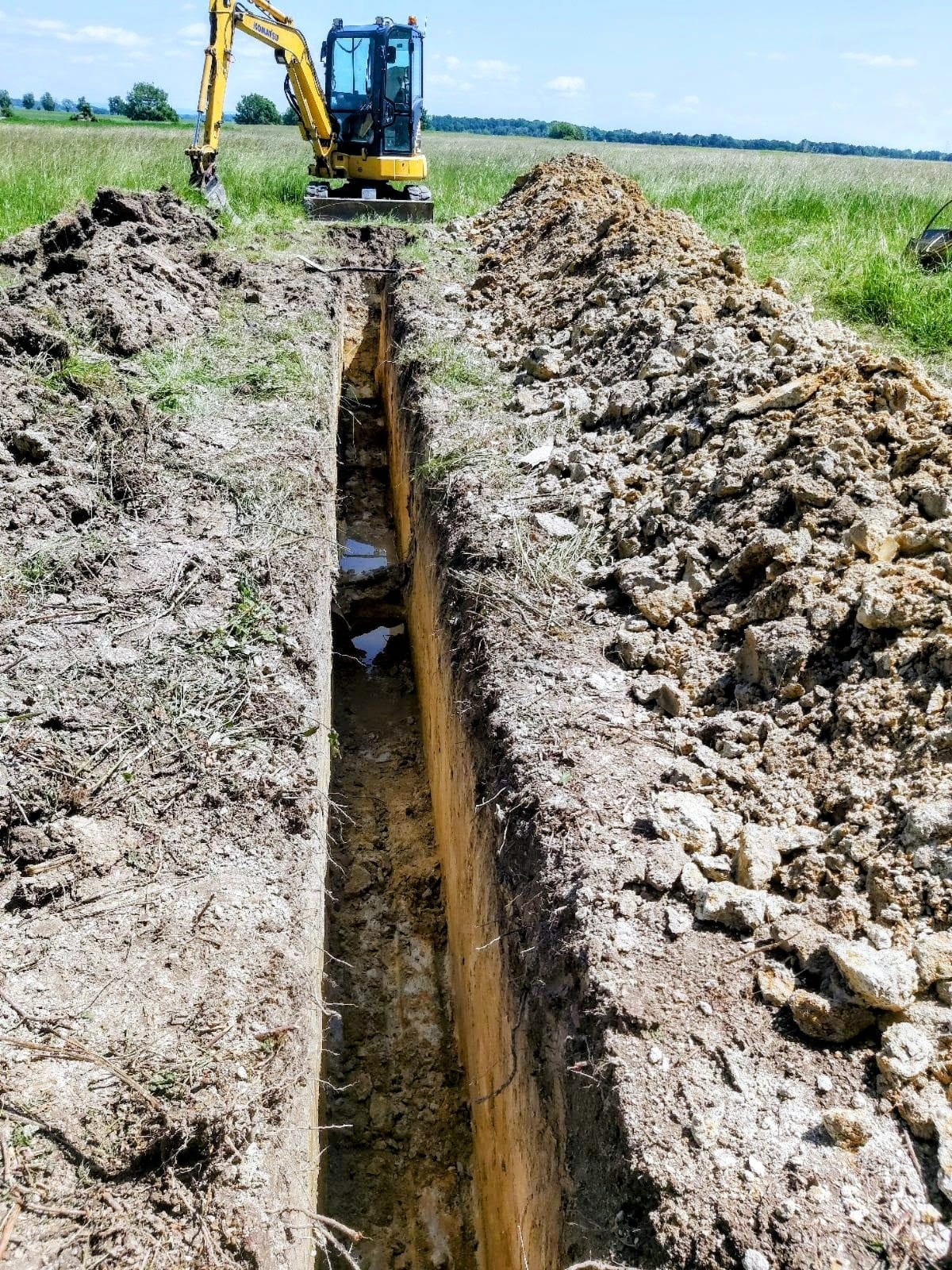 Výkop příkopu pro inženýrské sítě - bagr v jižních Čechách